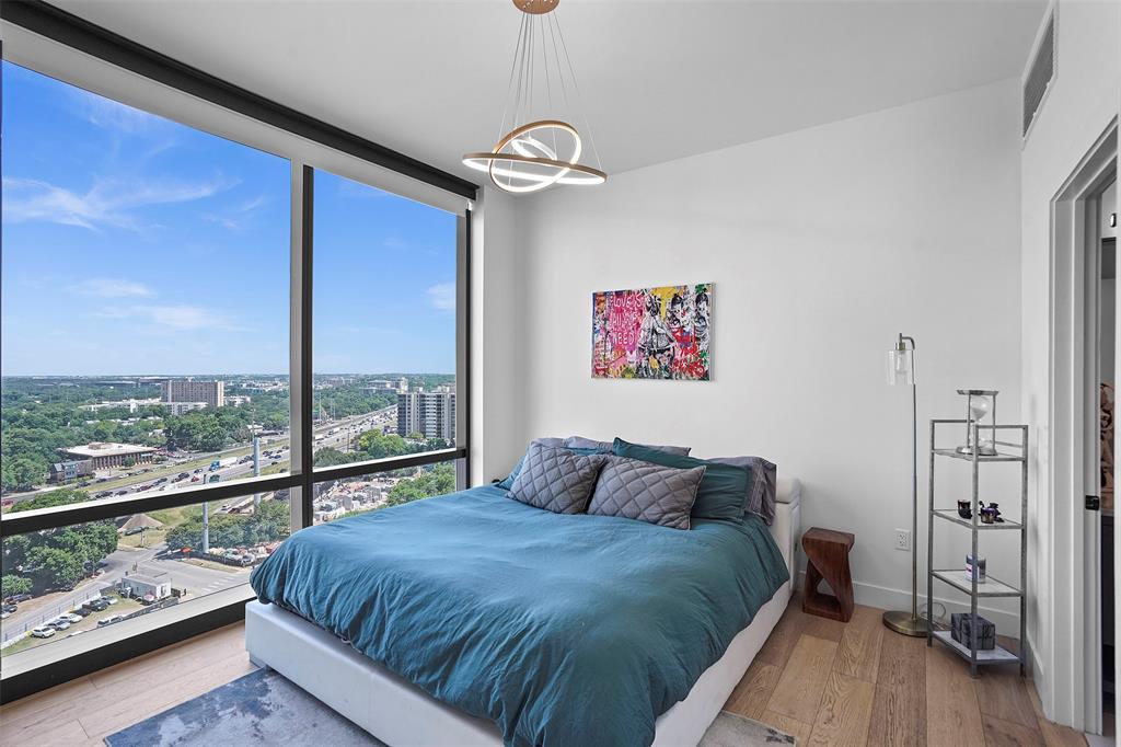 70 Rainey Street, Unit 1409 Austin, TX 78701 - Photo 11 of 38 Bedroom featuring wood-type flooring, expansive windows, and a view of city