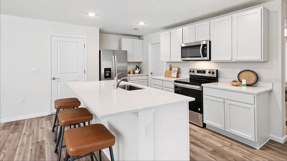 6855 Southwest 42nd Ct Road Ocala, FL 34476 - Photo 4 of 18 a kitchen with stainless steel appliances a stove a sink a microwave and cabinets