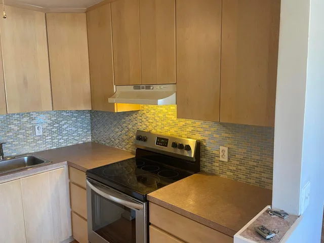 a kitchen with a stove and a white cabinet