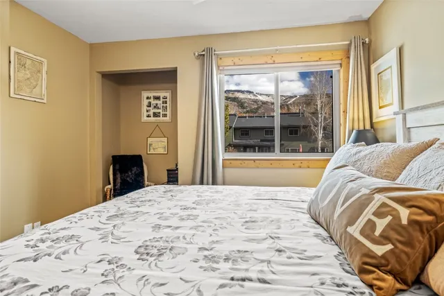 a bedroom with a bed and a large window