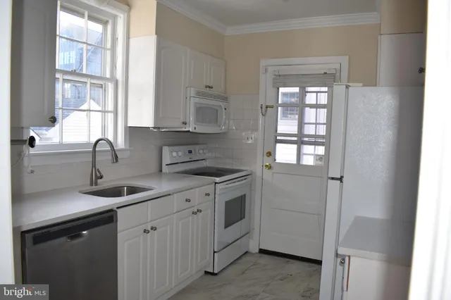a kitchen with sink a window and cabinets