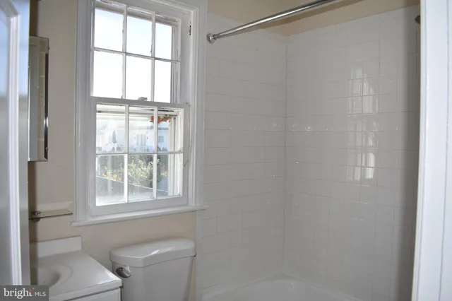 a bathroom with a toilet a sink and a window