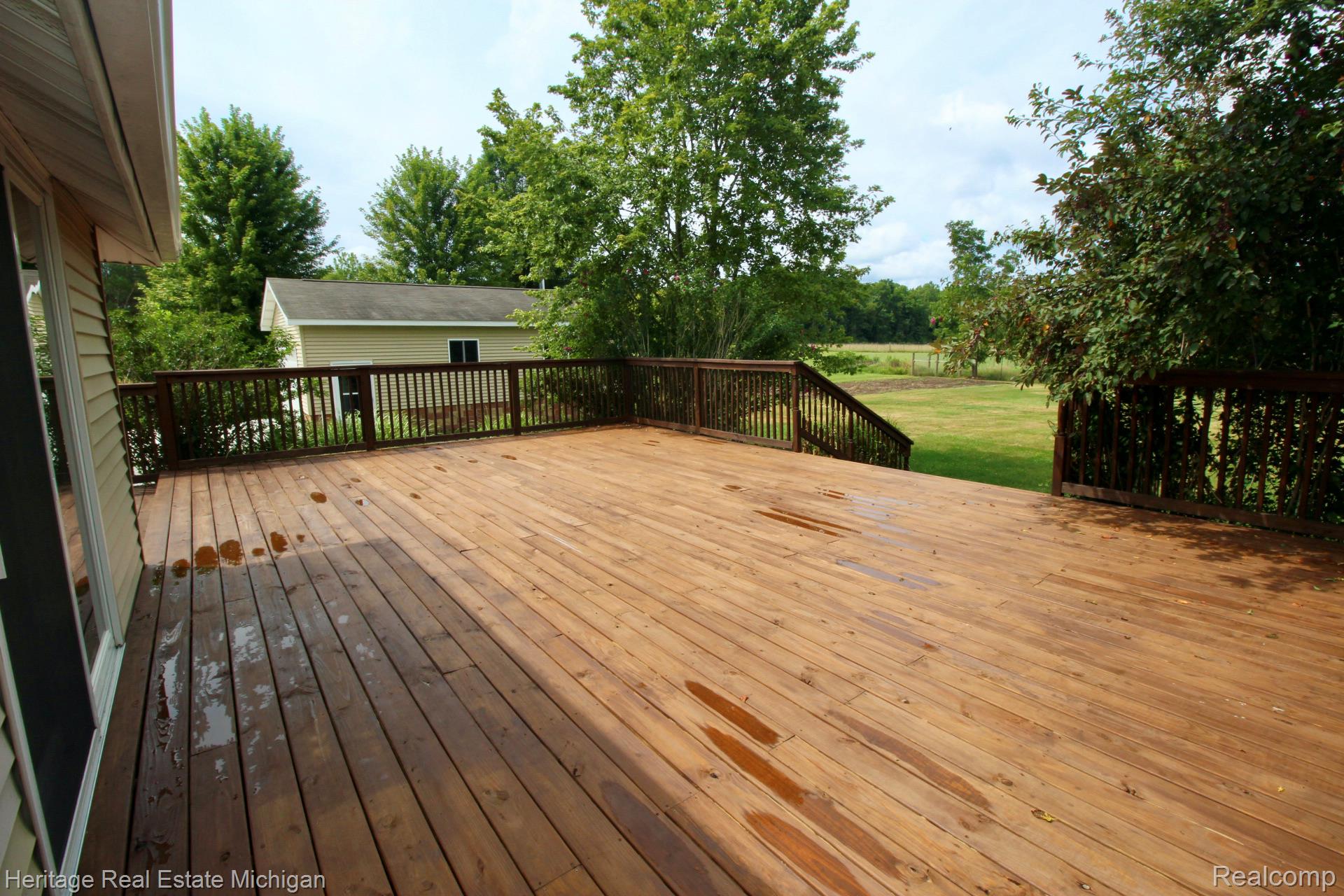 15352 South Duffield Road Byron, MI 48418 - Photo 26 of 47 Expansive wood deck with full railing and steps down to a green lawn