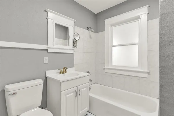 a bathroom with a sink toilet vanity and bathtub