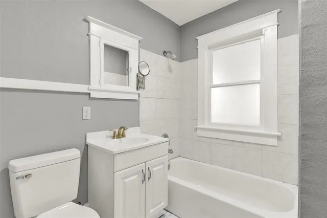 a bathroom with a sink toilet vanity and bathtub