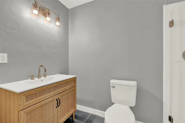 a bathroom with a toilet a sink and mirror