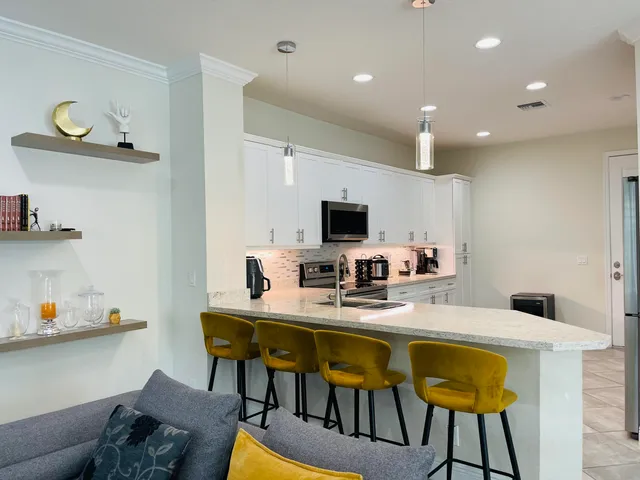 a view of a white house with a big yard and palm trees