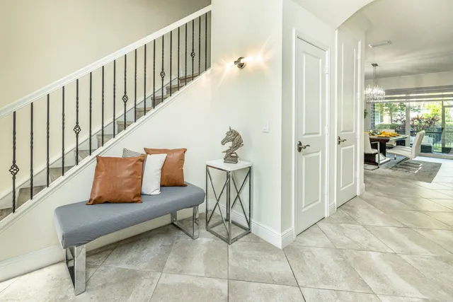 a bed sitting in a spacious bedroom next to a window and a chandelier