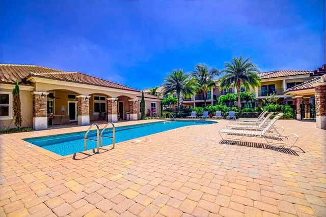 a view of a patio with table and chairs potted plants and floor to ceiling window