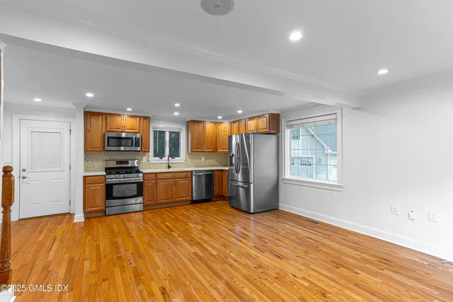 a large kitchen with stainless steel appliances granite countertop a stove a sink and a microwave