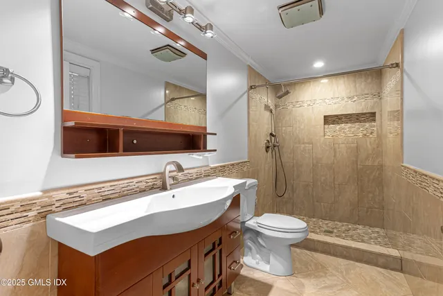 a bathroom with a sink toilet a mirror and shower