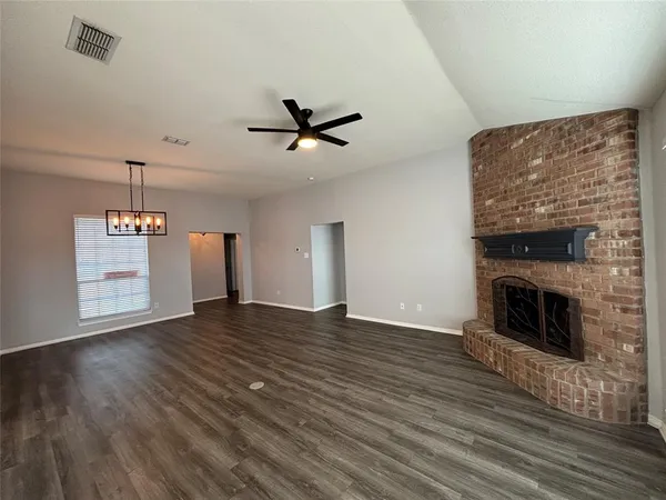 a view of empty room with wooden floor and fireplace