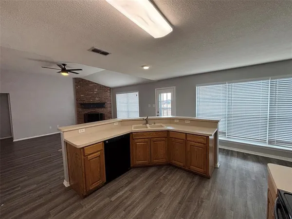 a large kitchen with wooden floor and stainless steel appliances