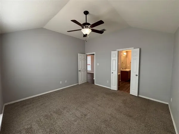 an empty room with closet and a chandelier fan