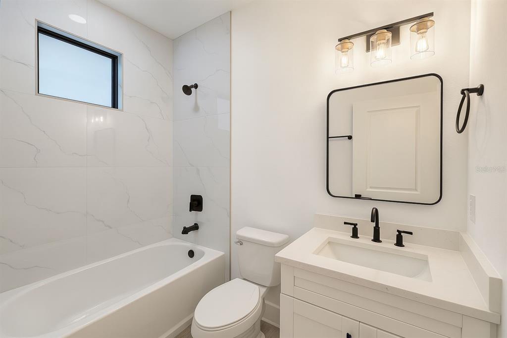 2967 Barry Road North Port, FL 34286 - Photo 12 of 16 a bathroom with a bathtub sink vanity mirror and toilet