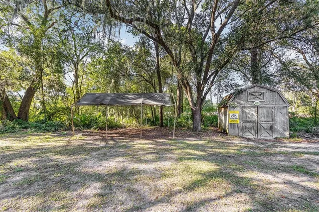 a front view of a house with a yard and large trees