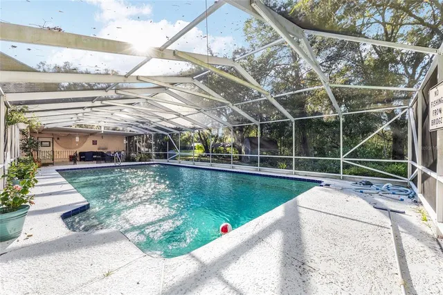 a view of a swimming pool with a patio and a yard