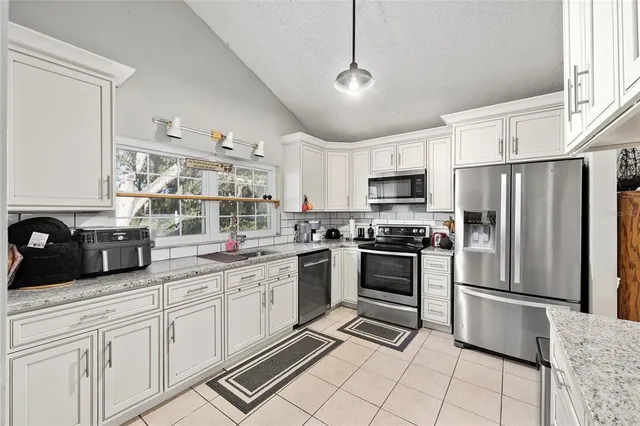 a kitchen with stainless steel appliances a refrigerator sink and microwave