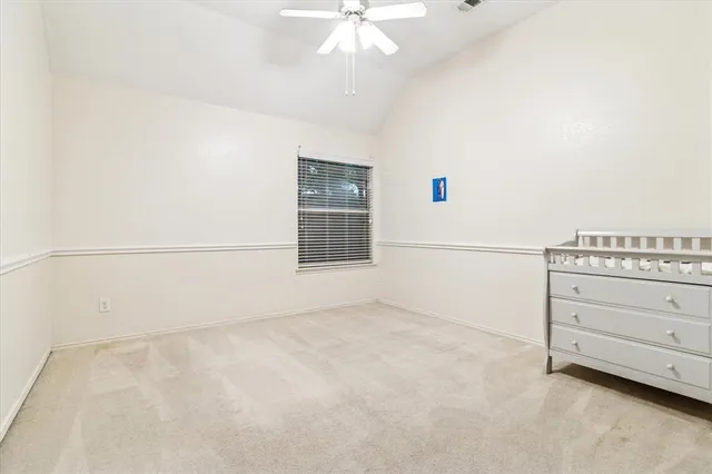 an empty room with a ceiling fan and a window