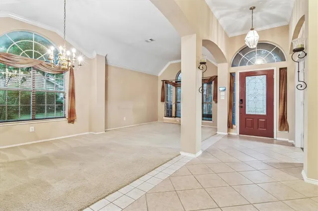 a view of a livingroom with a chandelier fan and windows