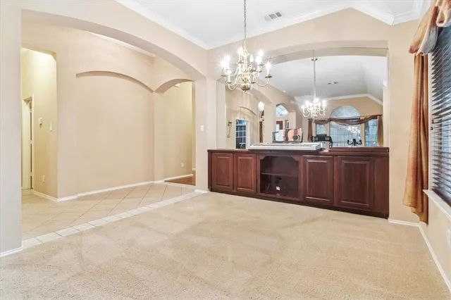 a view of a room with a chandelier and kitchen view