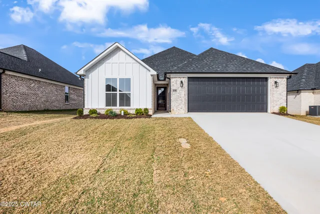 a view of a house with a yard and potted plants