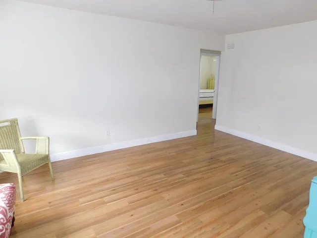 a view of an empty room and wooden floor