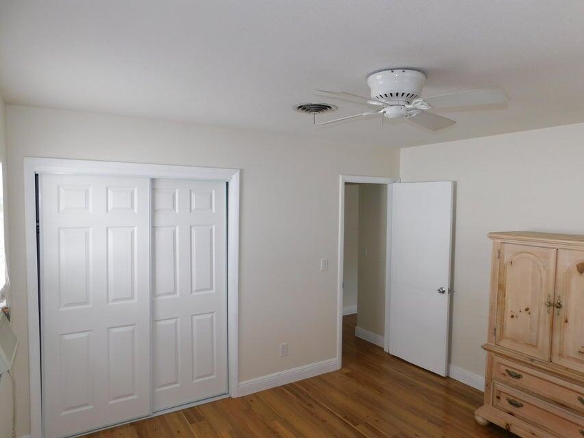 741 Hummingbird Way, Unit 8 North Palm Beach, FL 33408 - Photo 5 of 13 an empty room with wooden floor closet and windows