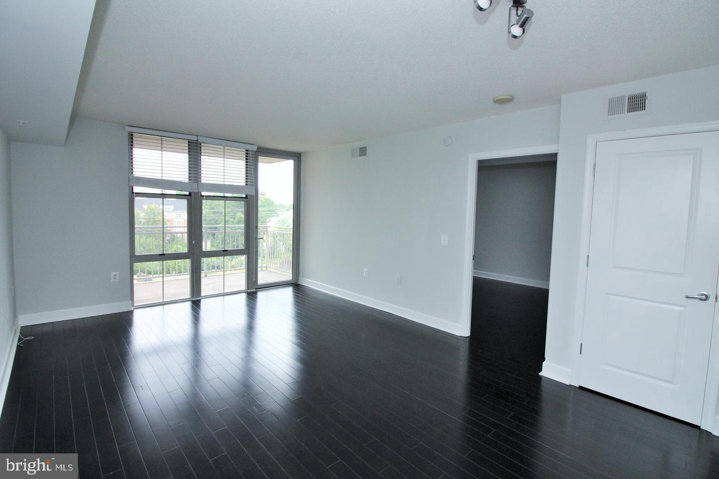 11800 Sunset Hills Road, Unit 625 Reston, VA 20190 - Photo 4 of 19 a view of an empty room with wooden floor and a window