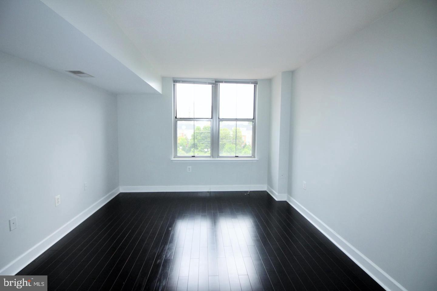 11800 Sunset Hills Road, Unit 625 Reston, VA 20190 - Photo 9 of 19 an empty room with wooden floor and windows