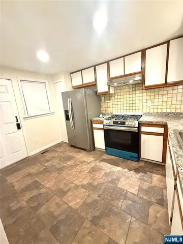 a kitchen with stainless steel appliances granite countertop a refrigerator and a sink