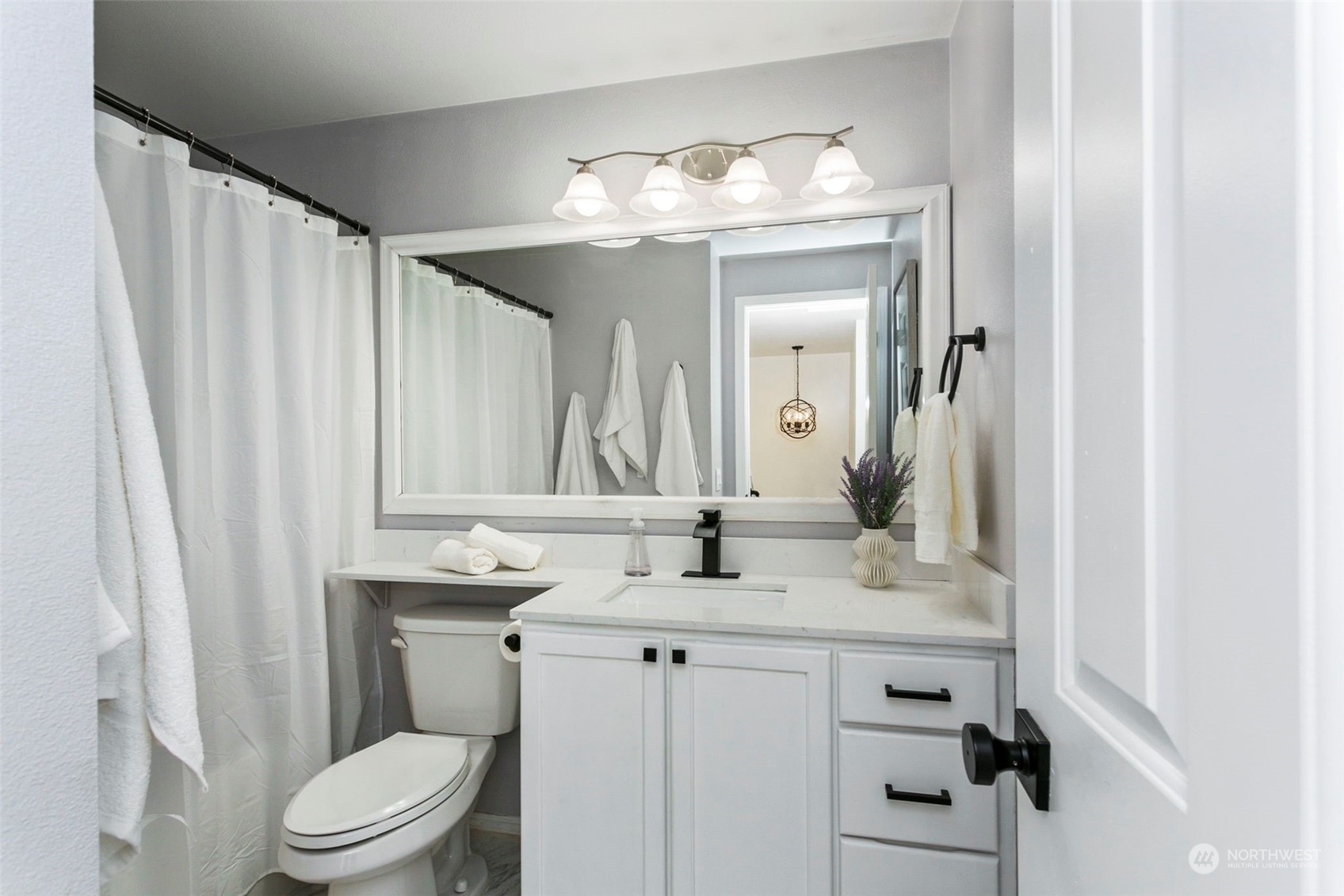 18930 Bothell Everett Highway, Unit J105 Bothell, WA 98012 - Photo 13 of 21 a bathroom with a granite countertop sink toilet a mirror and a shower