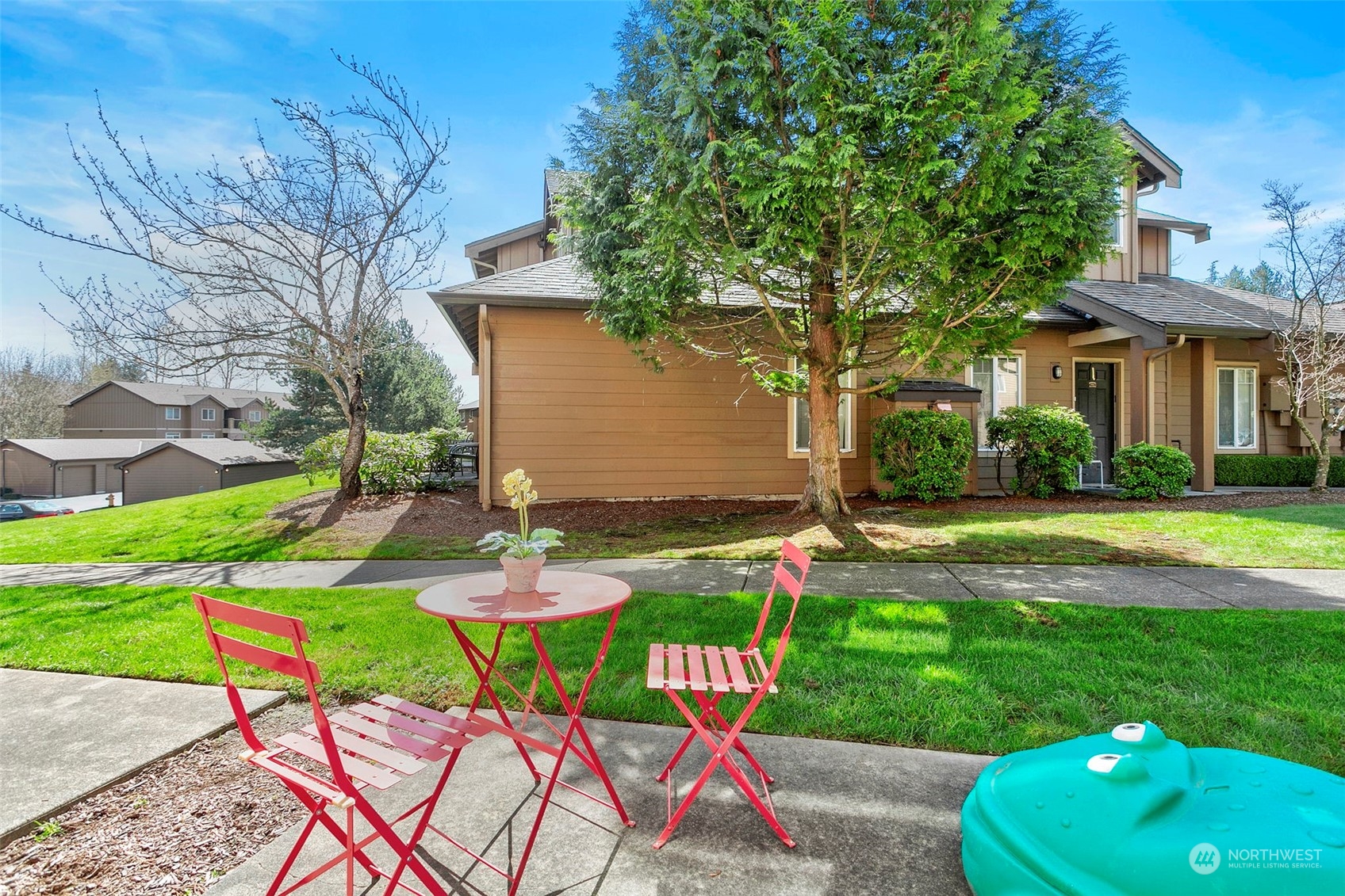 18930 Bothell Everett Highway, Unit J105 Bothell, WA 98012 - Photo 18 of 21 a patio with table and chairs and a yard
