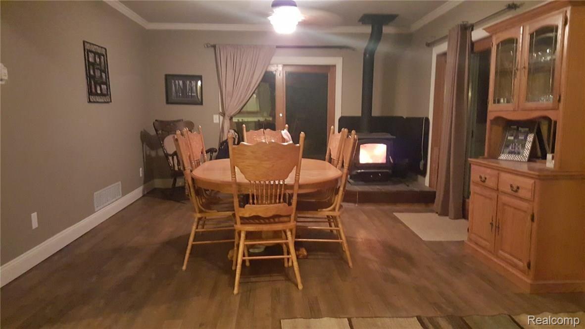 10140 Chase Lake Road Fowlerville, MI 48836 - Photo 4 of 22 Dinning room with wood burner and double door walls leading to large deck