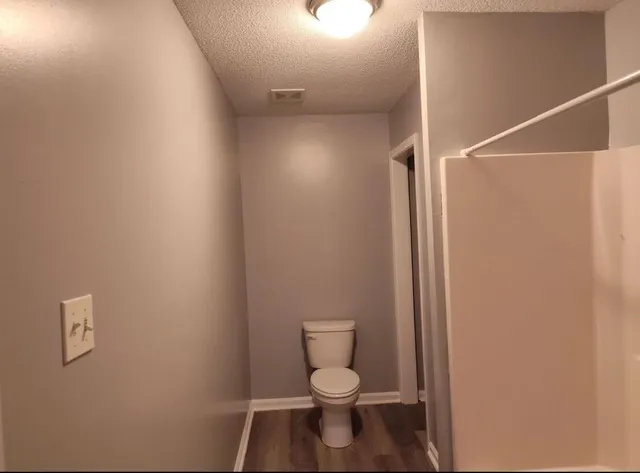 a white toilet sitting next to a shower