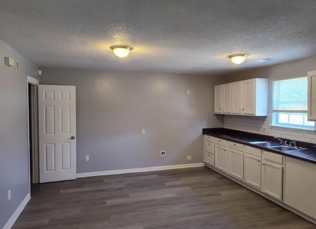 a kitchen with granite countertop a stove a sink and a microwave
