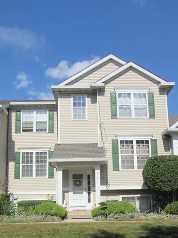 a front view of a house with a garden and plants