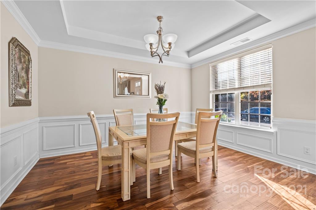 14448 Laurel Tree Lane Huntersville, NC 28078 - Photo 5 of 34 a dining room with furniture a chandelier and wooden floor
