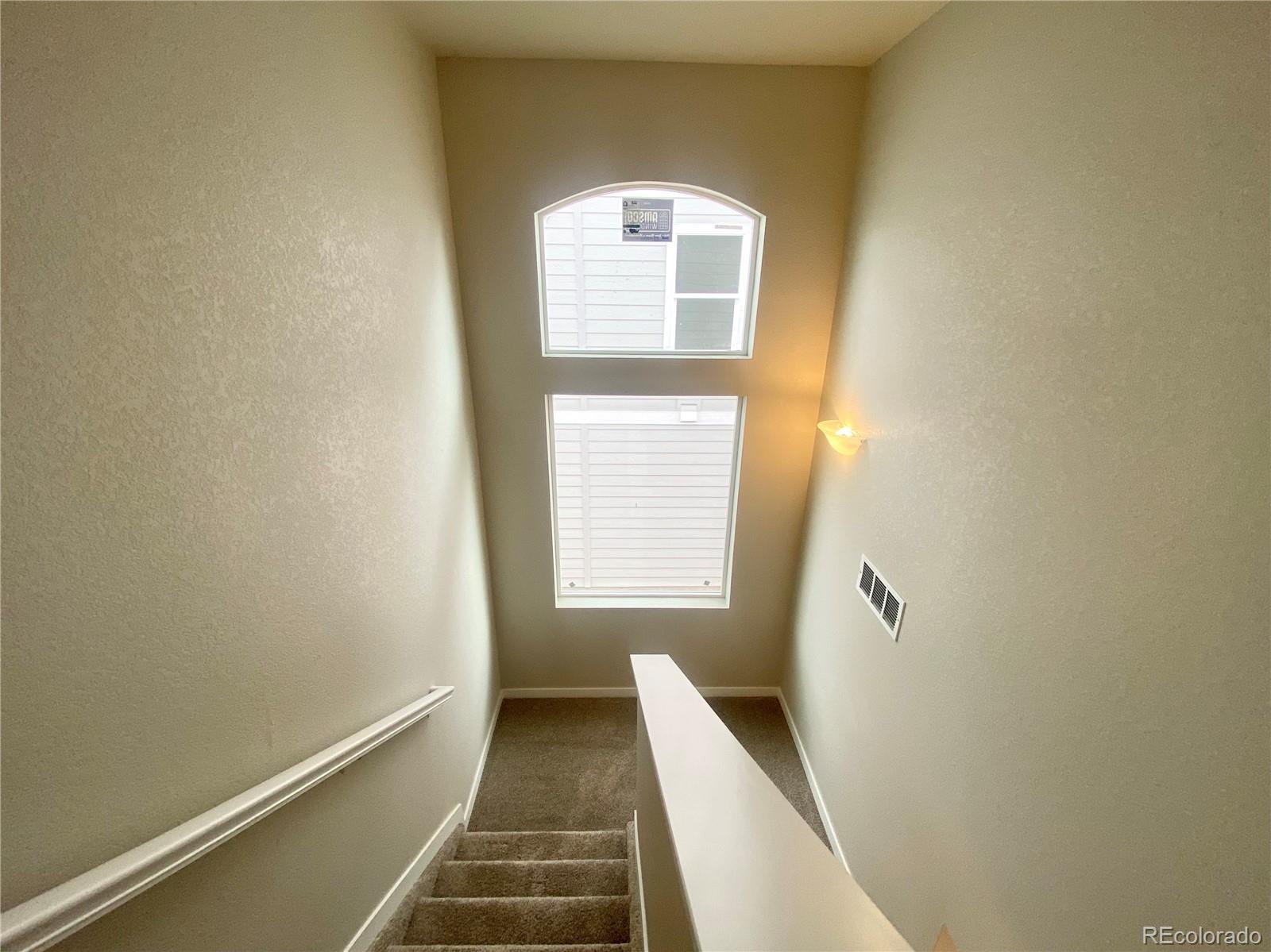 541 Ryan Avenue Fort Lupton, CO 80621 - Photo 13 of 29 a view of a hallway with wooden floor and a window