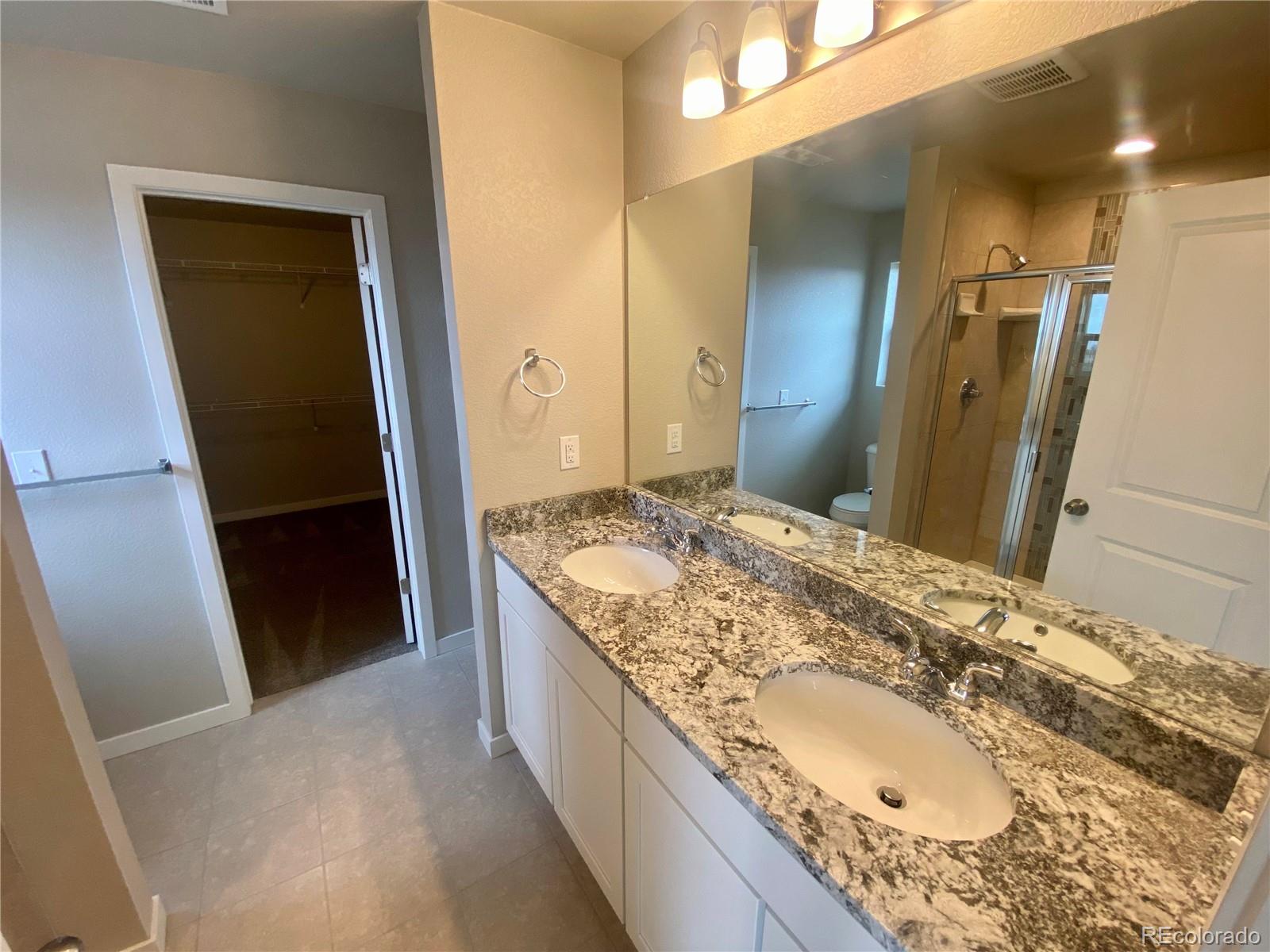 541 Ryan Avenue Fort Lupton, CO 80621 - Photo 16 of 29 a bathroom with a granite countertop sink and a mirror