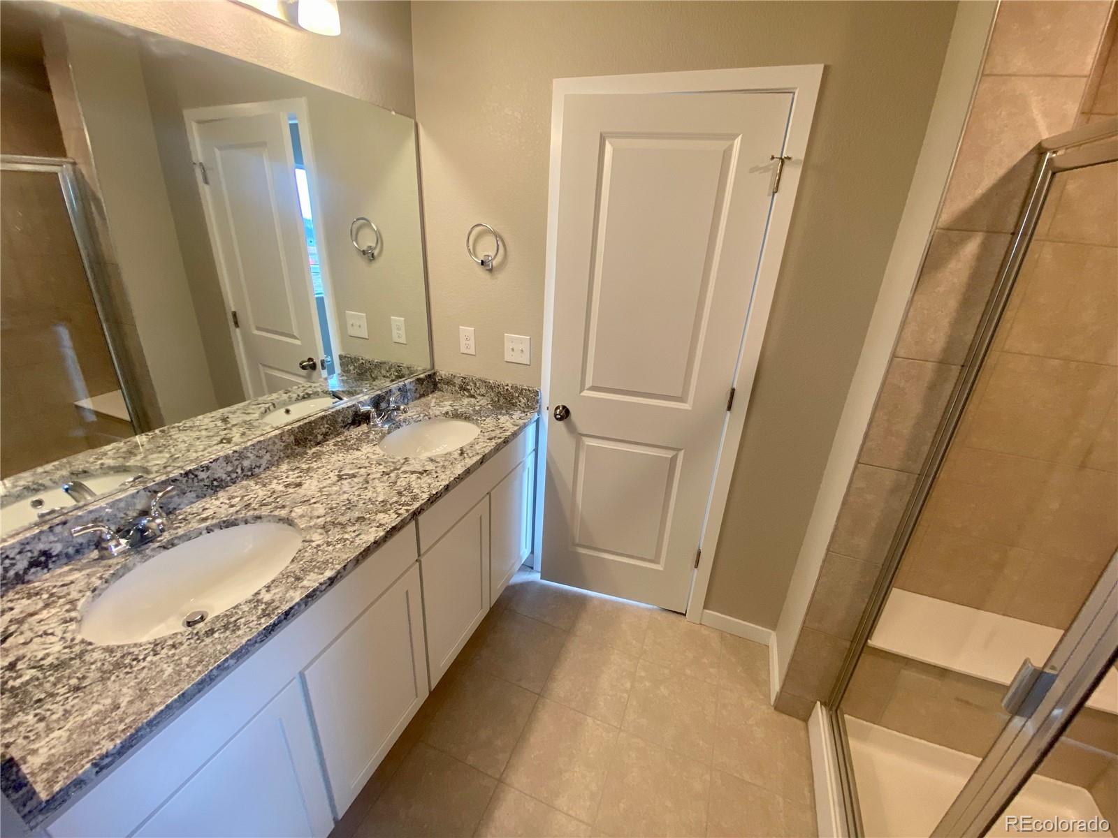 541 Ryan Avenue Fort Lupton, CO 80621 - Photo 19 of 29 a bathroom with a granite countertop sink and a mirror