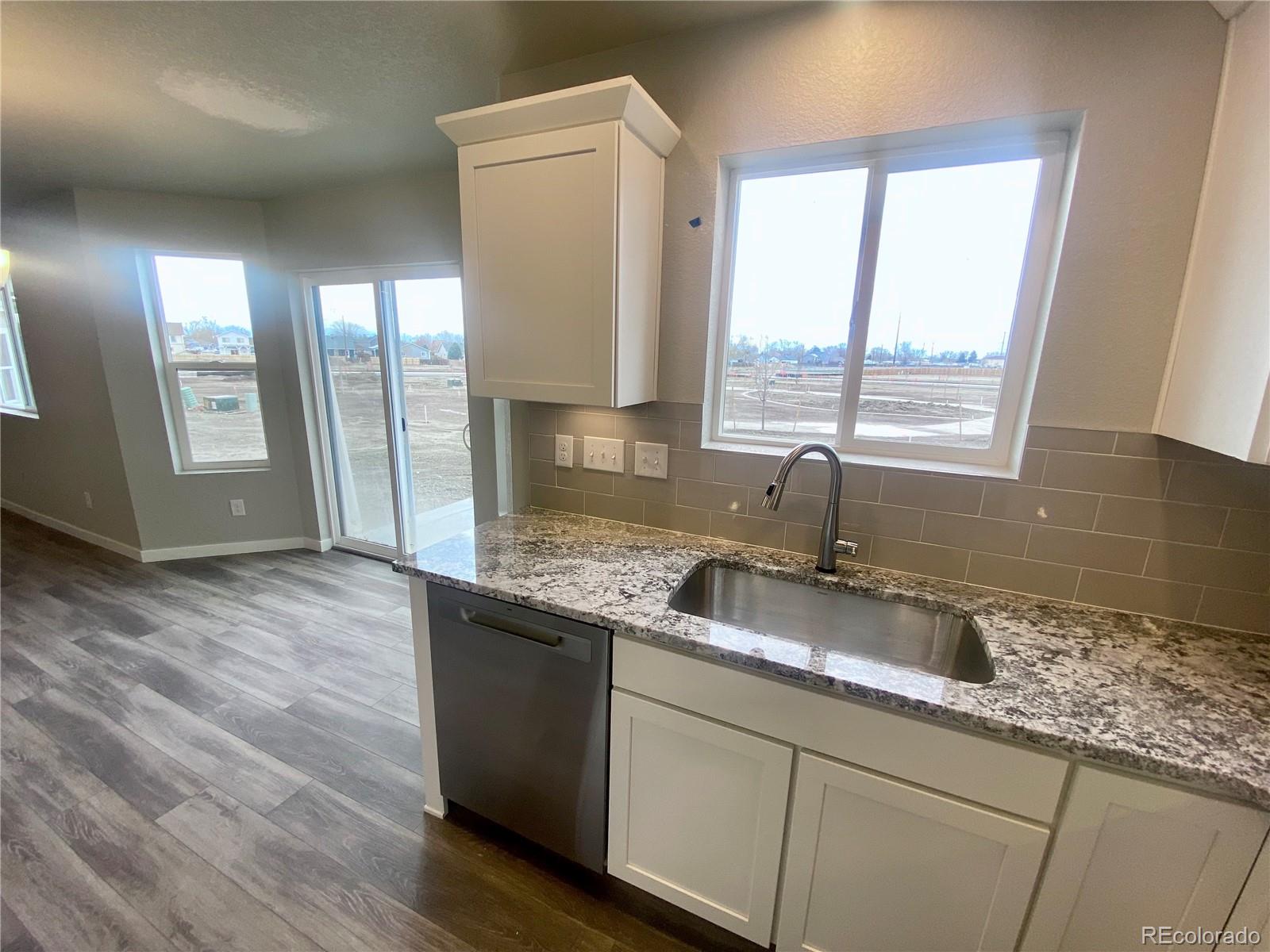 541 Ryan Avenue Fort Lupton, CO 80621 - Photo 6 of 29 a kitchen with granite countertop a sink and a window