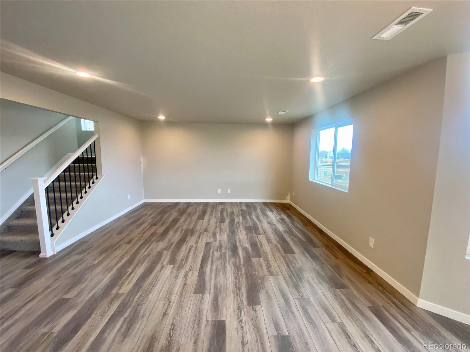 541 Ryan Avenue Fort Lupton, CO 80621 - Photo 8 of 29 wooden floor in an empty room with a window