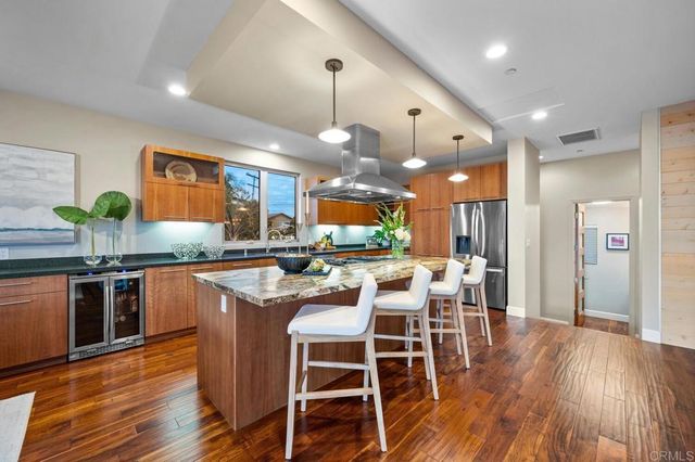 a kitchen with stainless steel appliances granite countertop wooden floors and table