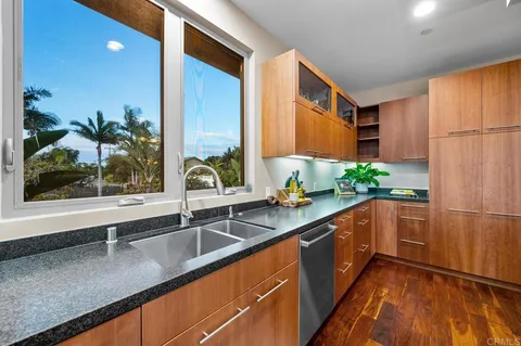 a kitchen with stainless steel appliances granite countertop a sink and a large window