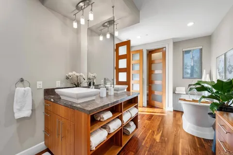 a living room with furniture a potted plant and a painting on the wall