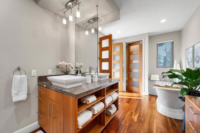 a living room with furniture a potted plant and a painting on the wall