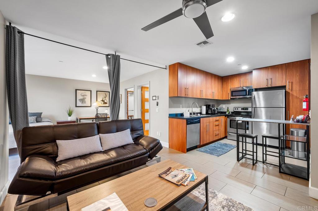 614 Ocean View Avenue Encinitas, CA 92024 - Photo 33 of 40 a kitchen with stainless steel appliances granite countertop a refrigerator a stove a sink dishwasher a dining table and chairs with wooden floor