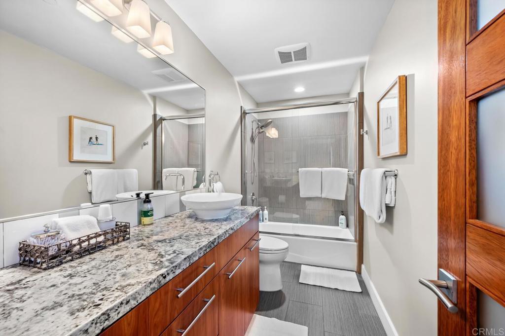614 Ocean View Avenue Encinitas, CA 92024 - Photo 35 of 40 a bathroom with a granite countertop sink a toilet and shower