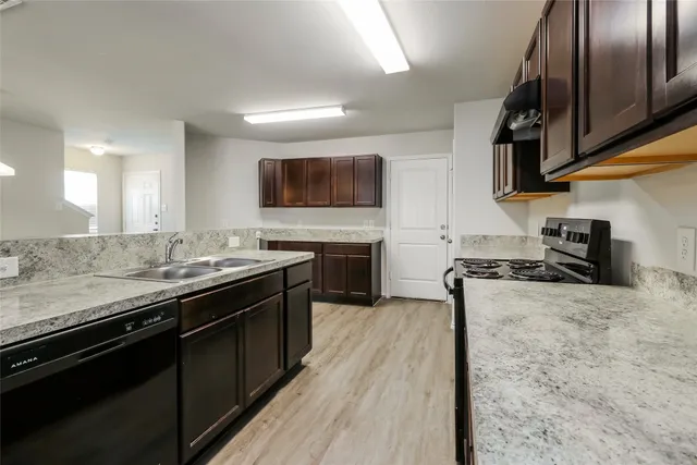 a kitchen with stainless steel appliances granite countertop a stove a sink and a microwave